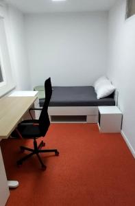 une chambre avec un lit, un bureau et une chaise dans l'établissement Apartma VAL - Maribor, à Maribor