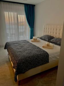 1 dormitorio con 2 camas, cortinas azules y ventana en Beach front apartment, en Bogazici