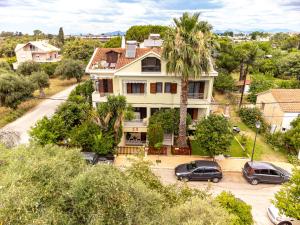 a house with two cars parked in front of it at Palmeira Studio in Preveza