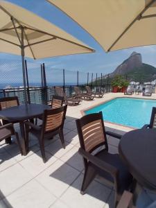 un patio con mesas y sillas y una piscina en TOP APART SERVICE's, en Río de Janeiro