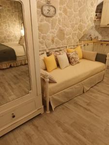 a couch sitting in a room with a mirror at TheHouse1905 in Parga
