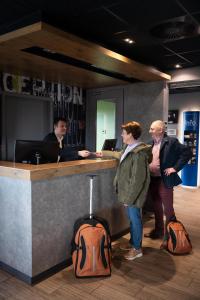 eine Gruppe von Personen, die vor einem Tresen stehen in der Unterkunft ibis budget Oostende Airport in Ostende