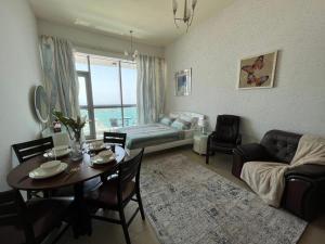 uma sala de estar com uma mesa e um sofá em luxury studio with amazing seaview em Ras al-Khaimah