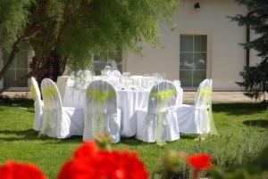a table with white chairs in the grass at Green Club in Tursko