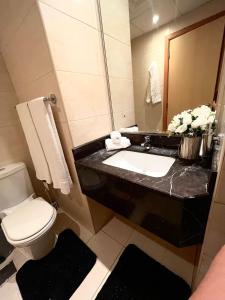 a bathroom with a sink and a toilet and a mirror at luxury studio with amazing seaview in Ras al Khaimah