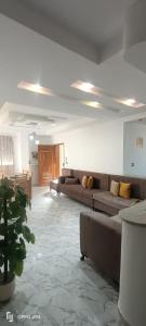 una gran sala de estar con sofás y una maceta en Residence Anas Kelibia, en Kelibia