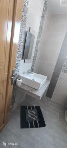 y baño con lavabo y espejo. en Residence Anas Kelibia, en Kelibia