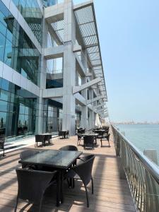 a building with tables and chairs next to the water at luxury studio with amazing seaview in Ras al Khaimah