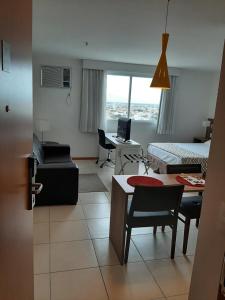 a living room with a room with a bed and a desk at Flat pensado para sua tranquilidade e alegria in Campos dos Goytacazes