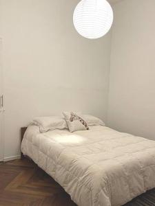 a bedroom with a bed with a white wall at Cálido apartamento a 8 cuadras del mar y a 3 de 18 Julio Hay una gatita que vive allí in Montevideo