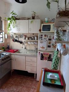 una cucina con frigorifero bianco e lavandino di Cálido apartamento a 8 cuadras del mar y a 3 de 18 Julio Hay una gatita que vive allí a Montevideo