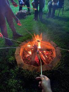 un grupo de personas de pie alrededor de un fuego en Pousada Chalés dos Montes en Santana dos Montes