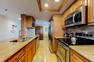 a kitchen with wooden cabinets and a stainless steel refrigerator at Water View 402 in Clearwater Beach