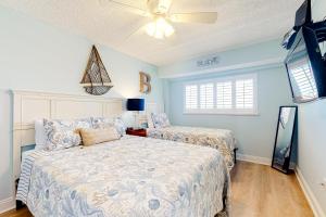 a bedroom with two beds and a ceiling fan at Water View 402 in Clearwater Beach