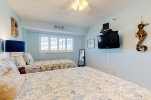 a bedroom with two beds and a flat screen tv at Water View 402 in Clearwater Beach +14 photos