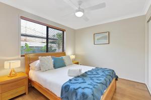 um quarto com uma cama e uma janela em Pet Friendly 5 BR Family Home w Pool at Caloundra em Caloundra West