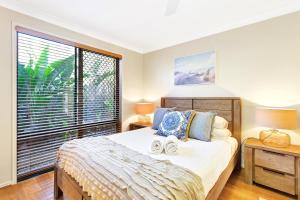 um quarto com uma cama e uma grande janela em Pet Friendly 5 BR Family Home w Pool at Caloundra em Caloundra West