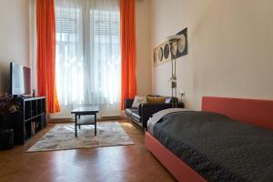 - une chambre avec un lit, un canapé et une télévision dans l'établissement Ili apartment, à Budapest