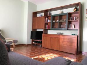 a living room with a large wooden entertainment center at Casa sul lago Nonna Gio' in Colle di Tora