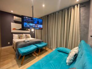 ein Wohnzimmer mit einem blauen Sofa und einem TV in der Unterkunft Rover República in São Paulo