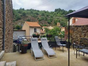 grupa krzeseł i stół na patio w obiekcie Gîte cosy avec jeux et terrasse à Auzon - FR-1-582-338 w mieście Auzon