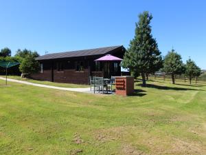 un edificio con una mesa de picnic en un campo en Willow Lodge, en Bodmin
