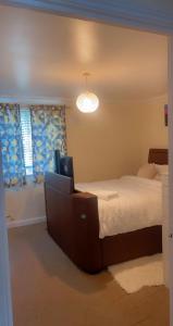 een slaapkamer met een groot bed en een licht bij Lovely 2 Bed Flat/Apt in East London- Nice Estate. in Dagenham