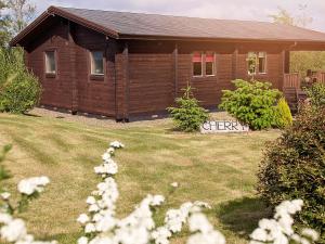 uma pequena casa com uma placa num quintal em Cherry Lodge em Bodmin