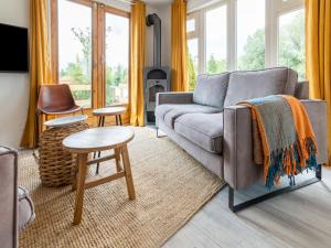 sala de estar con sofá y mesa en Idyllic holiday home in Ooltgensplaat on the water, en Ooltgensplaat