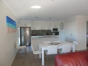 a kitchen with a white table and white chairs at Westwood Villas - Unit 2 in Bridport