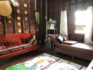 a living room with a couch and a chair at Bo Cabin in Garden โบคาบิน อิน การ์เดน in Ban Nong Ki