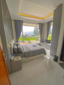 a bedroom with a bed and a large window at Algara Puncak Hotel in Puncak