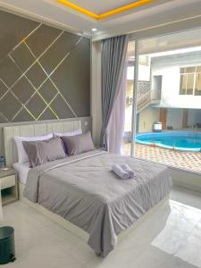 sypialnia z dużym łóżkiem i basenem w obiekcie Algara Puncak Hotel w mieście Puncak