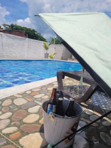 un cubo de botellas de vino sentado junto a una piscina en Cabaña El Faro, en Tubará