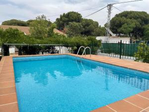 una gran piscina azul con una valla en EL ALFOLI. CASA RURAL CERCA DEL MAR en Aljaraque