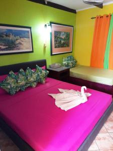 Una habitación con una cama rosa con un cisne. en Terrakota Apartments en Willemstad