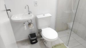 a white bathroom with a toilet and a sink at Mar dos Sonhos Suítes in Ubatuba +19 photos