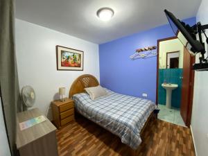 a small bedroom with a bed and a sink at Atenas Backpacker Hospedaje in Paracas