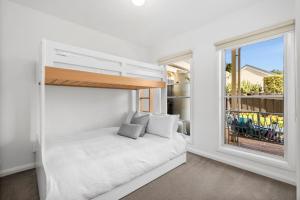 a bedroom with a bed and a large window at Villa by the Sea in Queenscliff