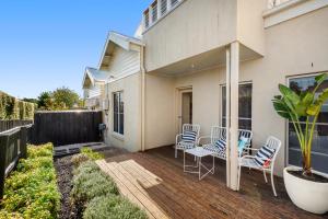 a patio with chairs and a table on a house at Villa by the Sea in Queenscliff