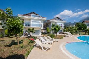 a villa with a swimming pool and lounge chairs at Villa Anemon in Fethiye