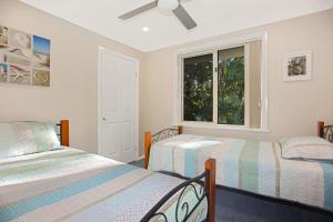 1 dormitorio con 2 camas y ventana en Perfect Family Accommodation Free WiFi, en Hawks Nest