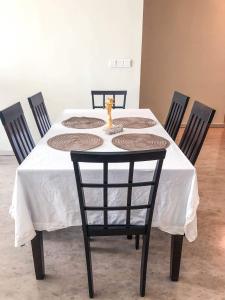 une table à manger avec une nappe blanche et quatre chaises dans l'établissement MyHabitat Residence Jalan Tun Razak, à Kuala Lumpur