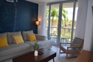 uma sala de estar com um sofá e uma mesa em Lovely 1 Bedroom condo 1 Bath w patio & kitchen em Hallandale Beach