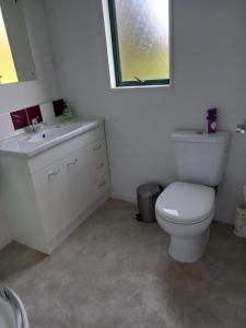 a bathroom with a white toilet and a sink at Aramatai Gardens in Te Kuiti