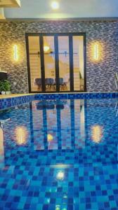a swimming pool with blue tiles in a house at Spring Fields Homestay by Sizma in Semenyih