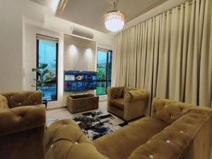a living room with a couch and two chairs at Spring Fields Homestay by Sizma in Semenyih