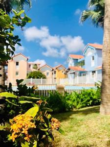 a group of houses in a yard with flowers at Hamo Cosy in Sainte-Anne