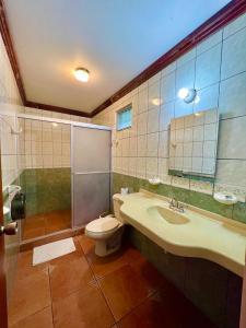 y baño con aseo, lavabo y ducha. en Hotel Sierra Arenal en Fortuna