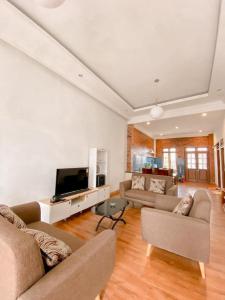 uma sala de estar com 2 sofás e uma televisão de ecrã plano em AINUN VILLA DIENG em Banjarnegara